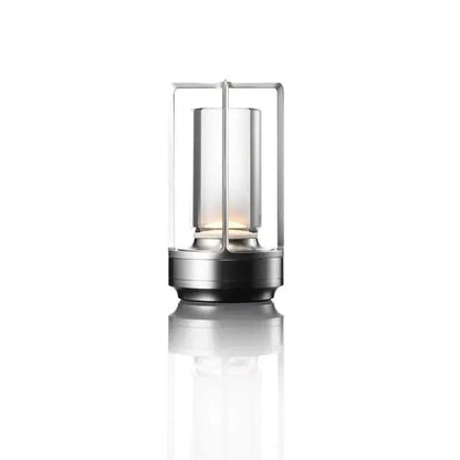 Cordless table lamp with metal cage and warm glow on a camping table