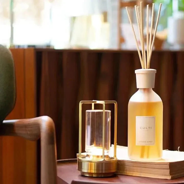 Cordless table lamp with metal cage and warm glow on a camping table