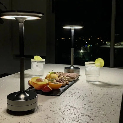 Cordless table lamp with aluminum body on an outdoor dining table