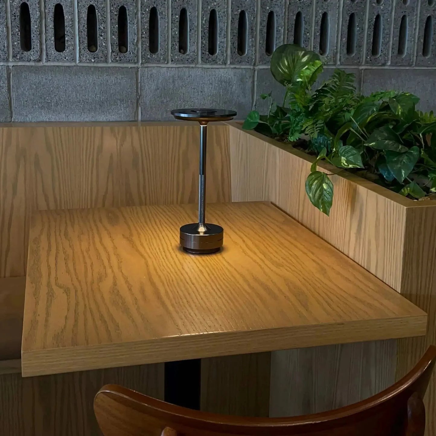 Cordless table lamp with aluminum body on an outdoor dining table