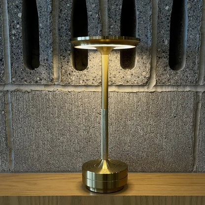Cordless table lamp with aluminum body on an outdoor dining table