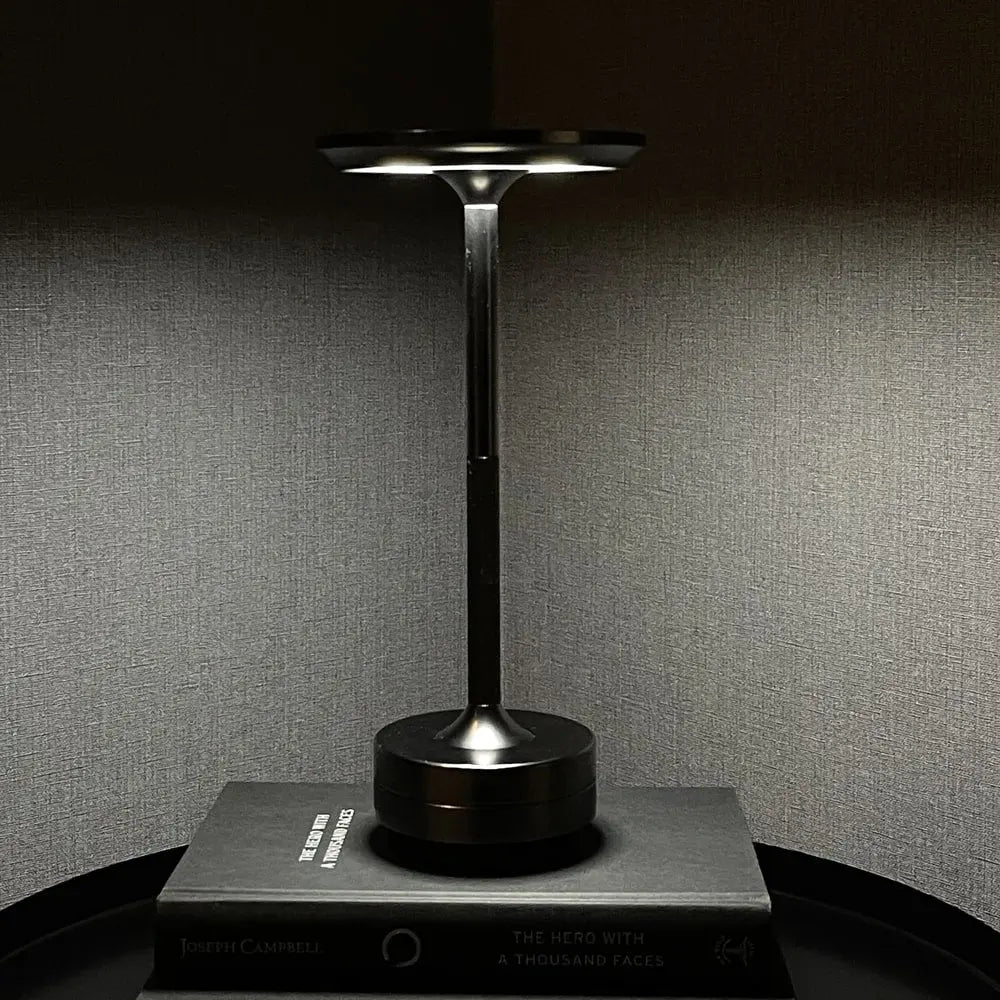 Cordless table lamp with aluminum body on an outdoor dining table