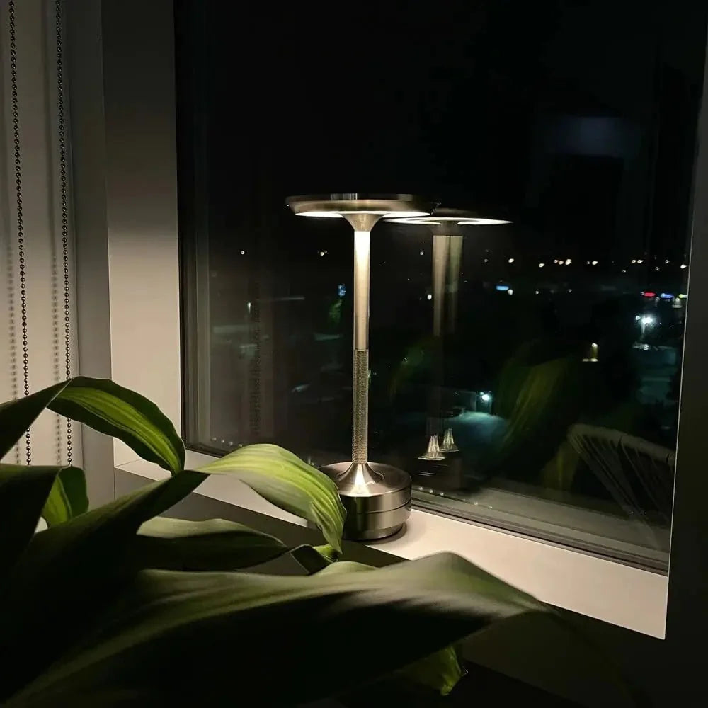 Cordless table lamp with aluminum body on an outdoor dining table