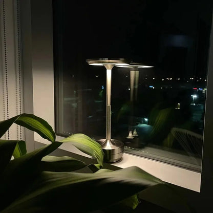Cordless table lamp with aluminum body on an outdoor dining table