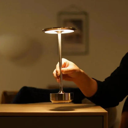 Cordless table lamp with aluminum body on an outdoor dining table