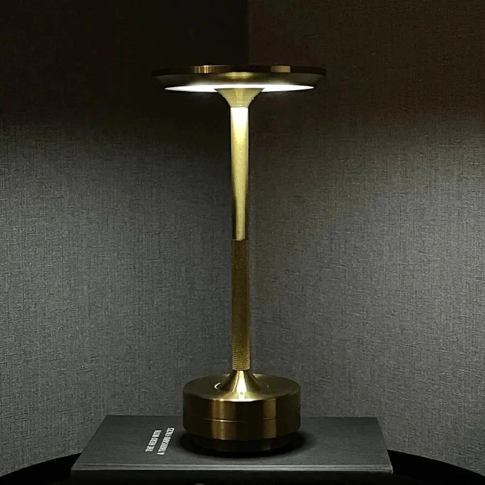 Cordless table lamp with aluminum body on an outdoor dining table