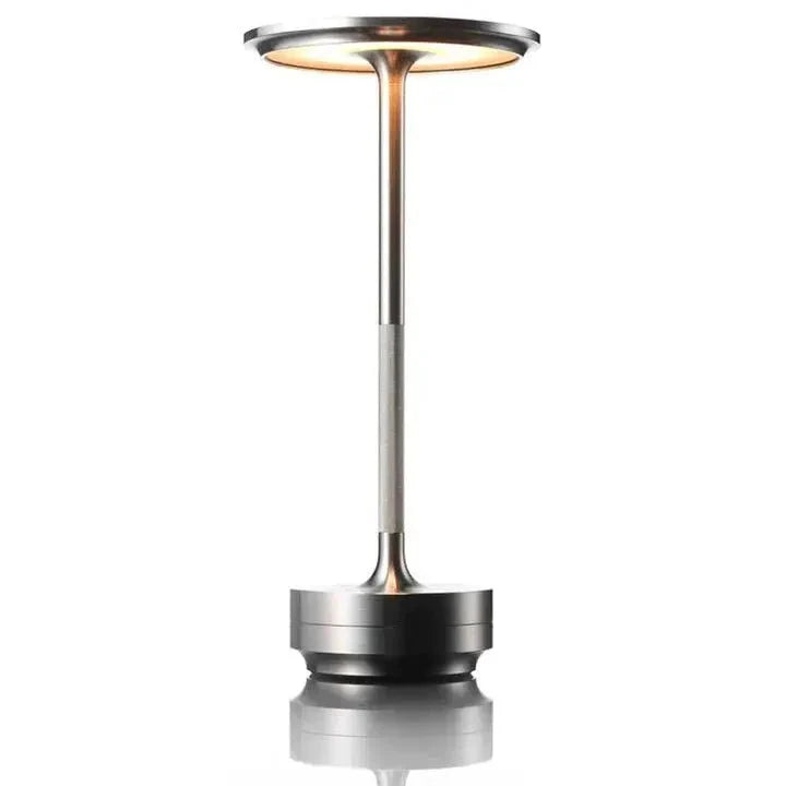 Cordless table lamp with aluminum body on an outdoor dining table