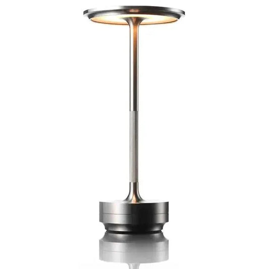 Cordless table lamp with aluminum body on an outdoor dining table
