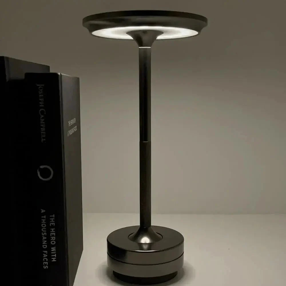 Cordless table lamp with aluminum body on an outdoor dining table