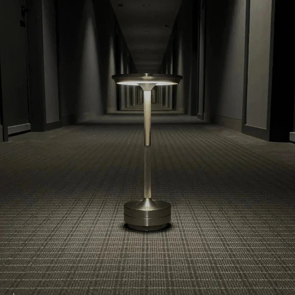 Cordless table lamp with aluminum body on an outdoor dining table