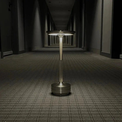 Cordless table lamp with aluminum body on an outdoor dining table