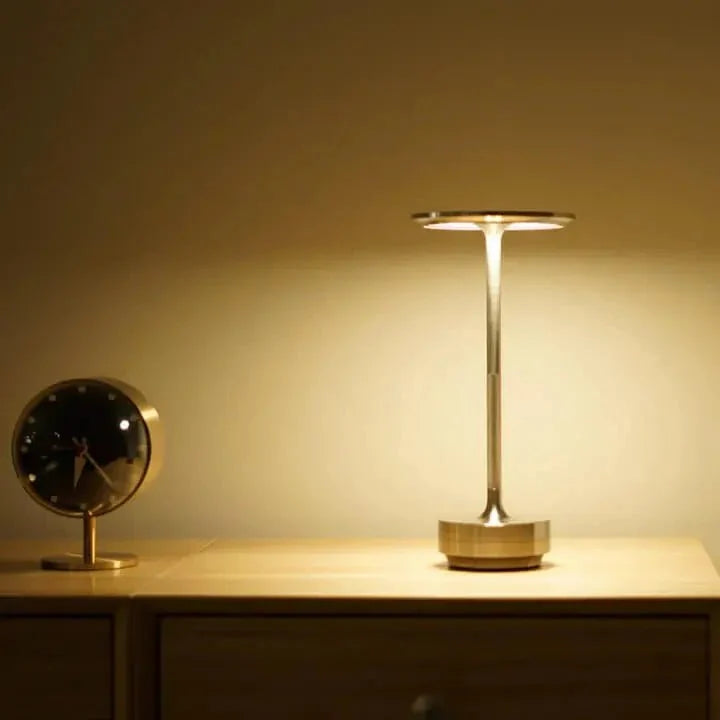Cordless table lamp with aluminum body on an outdoor dining table