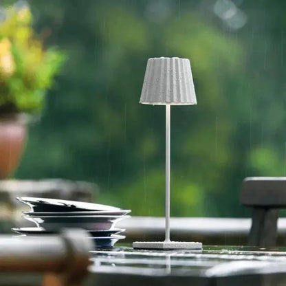 Cordless waterproof LED table lamp on a patio table for outdoor entertaining