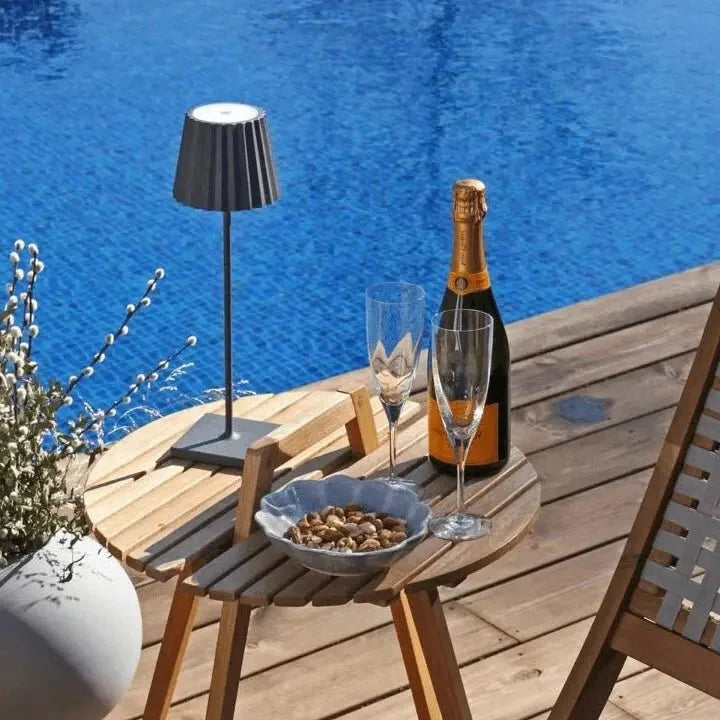 Cordless waterproof LED table lamp on a patio table for outdoor entertaining
