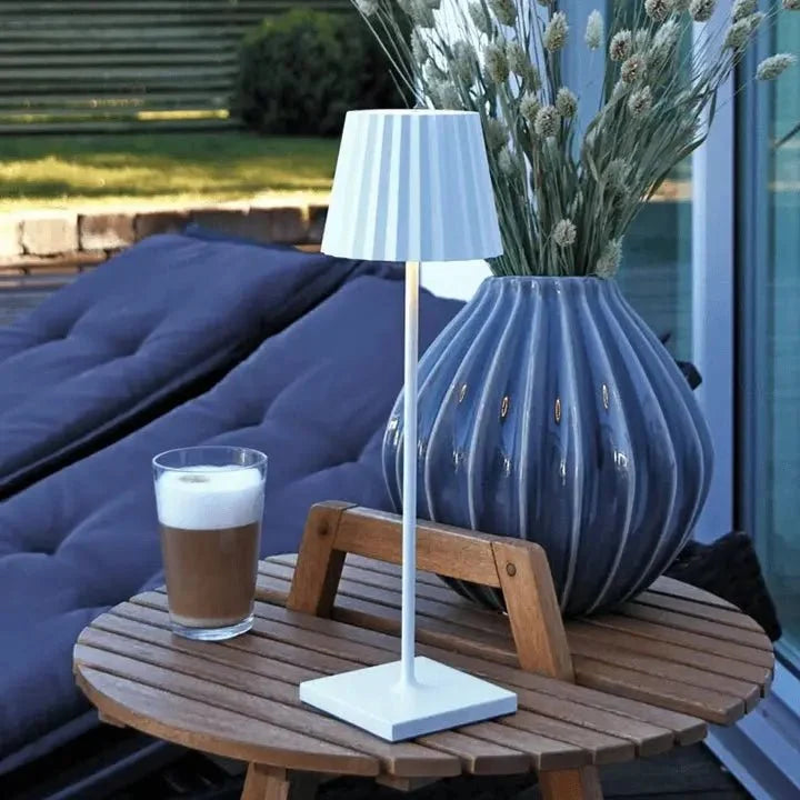 Cordless waterproof LED table lamp on a patio table for outdoor entertaining