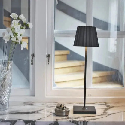 Cordless waterproof LED table lamp on a patio table for outdoor entertaining