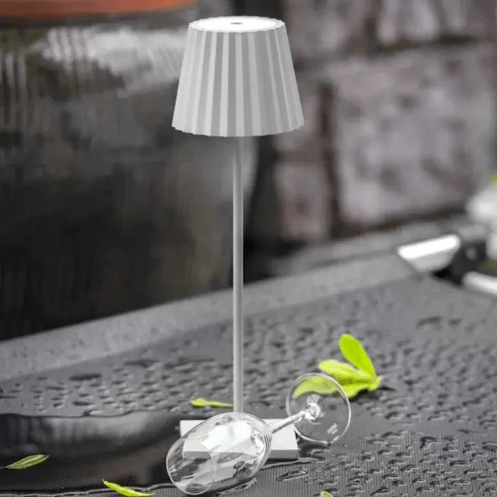 Cordless waterproof LED table lamp on a patio table for outdoor entertaining