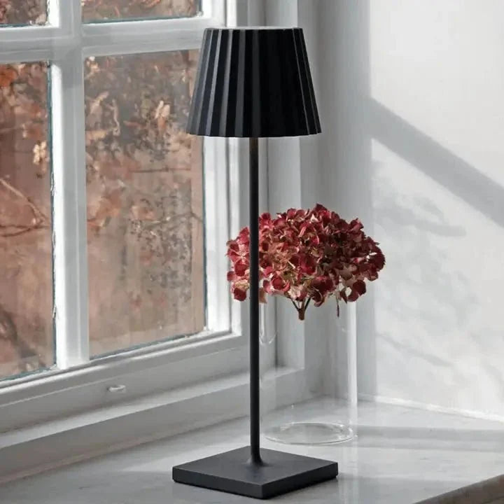 Cordless waterproof LED table lamp on a patio table for outdoor entertaining
